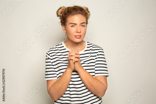 Portrait of cunning young woman on light background