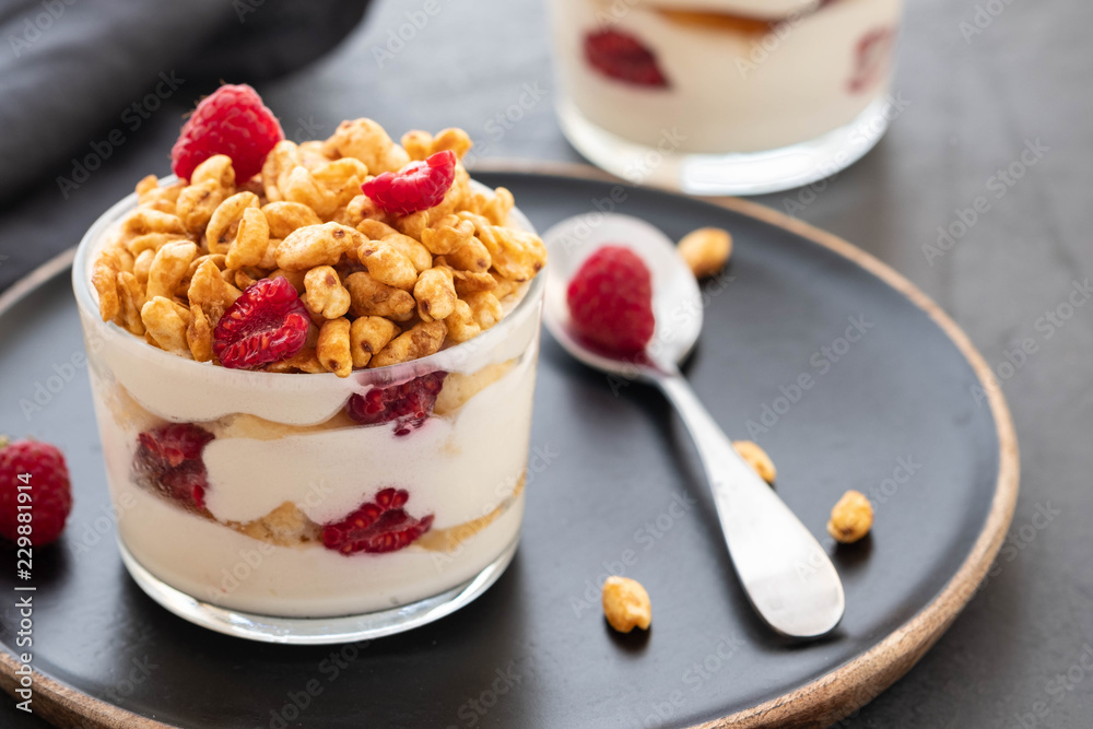 Fresh yoghurt with rasberry in clear glass. Raspberries in white bowl. Healthy morning breakfast.