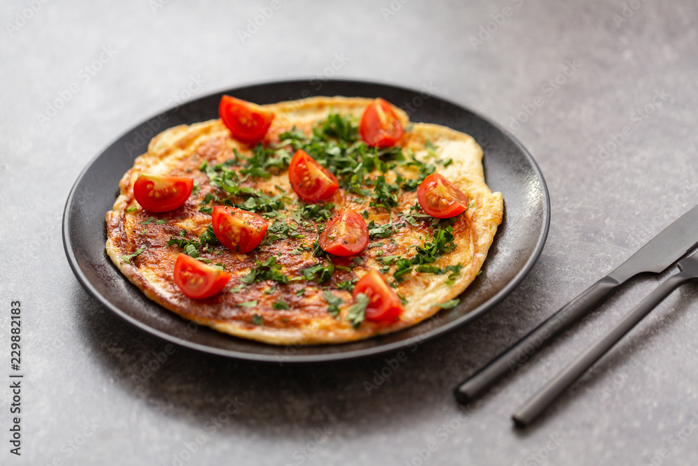 Omelet with tomatoes and herbs. Delicious breakfast
