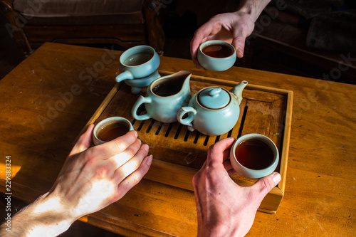 Tableau sur toile 3 people tasting and drinking dark oolong tea into small tasting cups - Shot dur