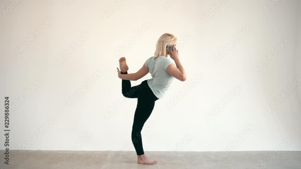 Model size plus practice yoga lord pose and use smartphone at white background Model size plus practice yoga lord pose and use smartphone at white background