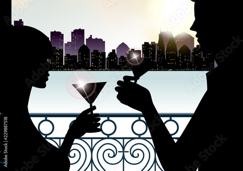 Silhouette of a couple toasting with martini glasses