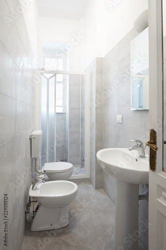 Renovated narrow bathroom with gray cement tiles