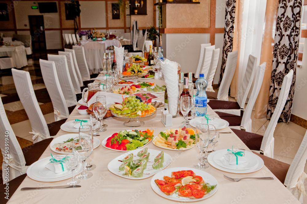 Festive table with gourmet food is set in a cafe or restaurant