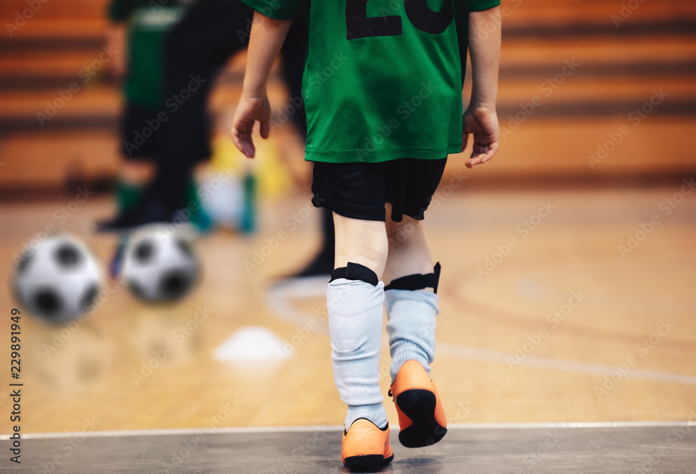 Kids futsal training. Indoor soccer players training with balls. Sport background. Indoor soccer sports hall. Futsal player, ball, futsal floor on health and physical education class. Futsal league.