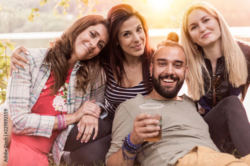 group of four friends posing for a portrait while chilling during an outdoor party