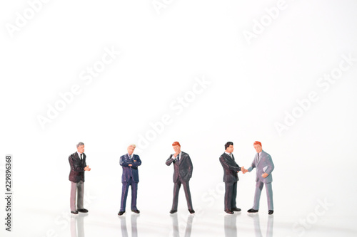Miniature people: a group of businessman standing on white background (this image for financial and business competition concept).