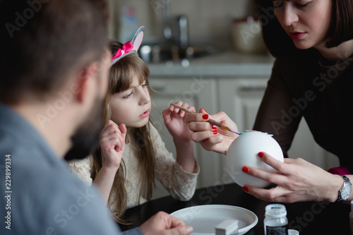 Mother is teaching her daughter how to make DIY Christmas tree ball