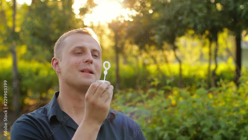 Adult man blowing big soap bubbles. concept of nostalgia for childhood Adult man blowing big soap bubbles. concept of nostalgia for childhood