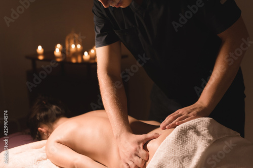 Close-up of male hands. Masseur does massage for the waist of a young girl. Rehabilitation, beauty therapy medicine. healthy concept