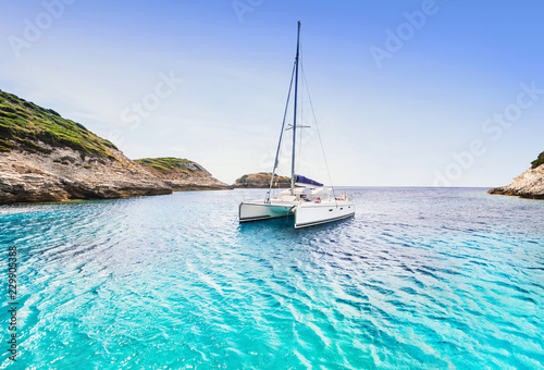 Billede på lærred Beautiful bay with sailing boat catamaran, Corsica island, France