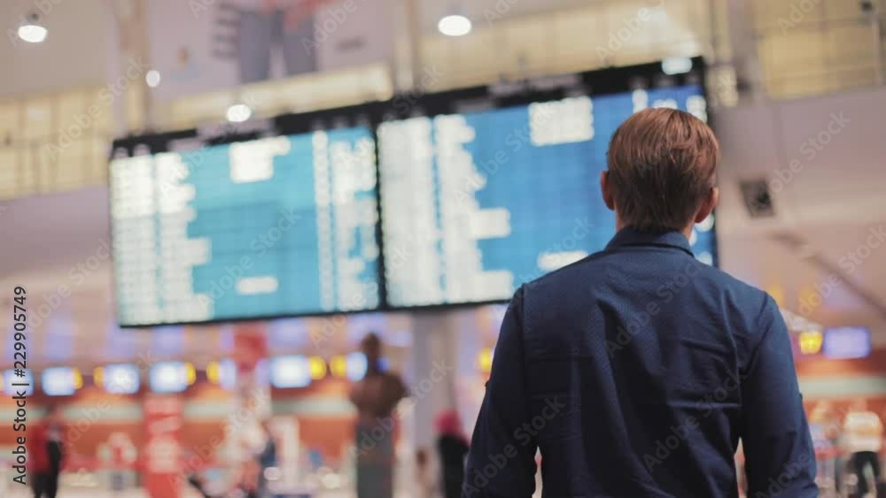 Shot back young man in modern airport terminal travelling guy wearing smart casual style clothes walking away airline arrival flight journey lifestyle passenger plane tourist hall indoors