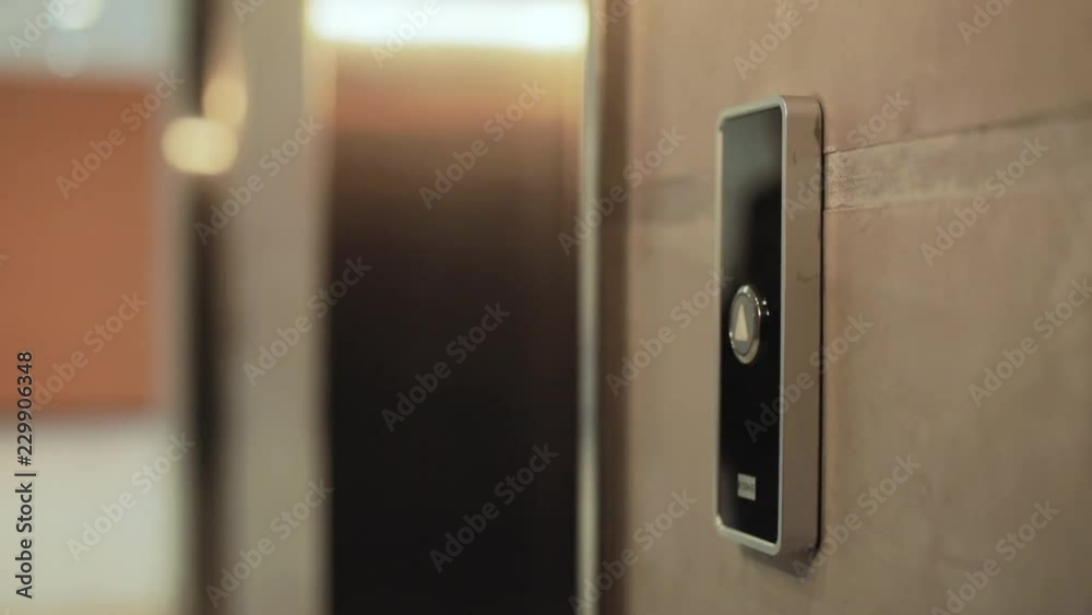 Close up hand young businessman presses a button of lift to go up by a finger elevator business technology lift push building interior down choice control office open door Close up hand young businessman presses a button of lift to go up by a finger elevator business technology lift push building interior down choice control office open door