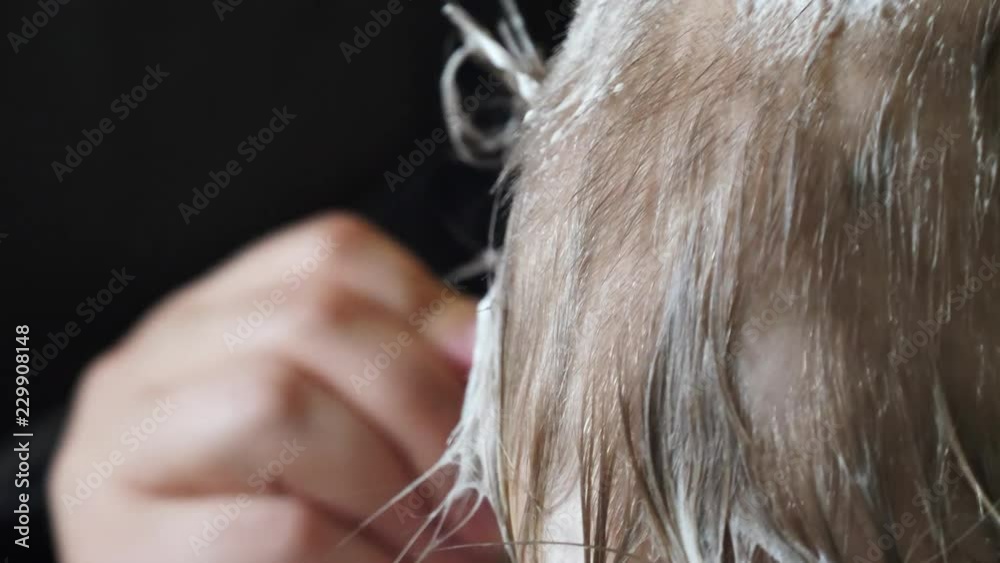 Young mother shaves head of blond boy with razor for preventing pediculosis. Good family tradition. Child is happy from hygiene procedures.