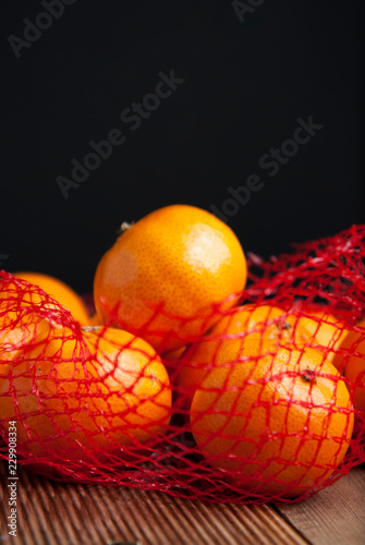 Citrus Fruits Tangerine in Oranges in plastic net bag package. no plastic concept. Packaging that does not recycle. Plastic. Rustic wooden background. photo