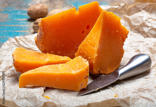 Pieces of native French aged cheese Mimolette, produced in Lille with greyish curst made by special cheese mites