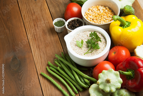 Health food with high fibre. Dietting, whole wheat cerals, grains, vegetables, antioxidants and vitamins: zzuchini, tomatoes, cucumbers, beans. Rustic wooden background top view.