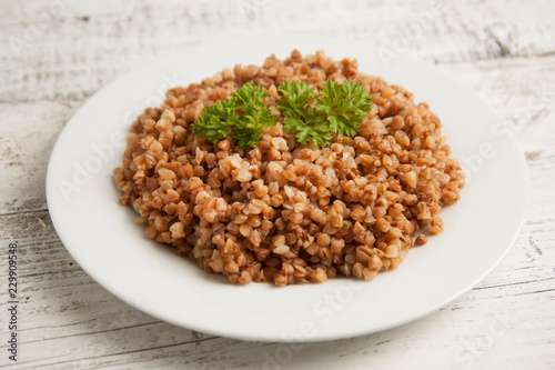Cooked buckwheat on white wooden background. Healthy food.