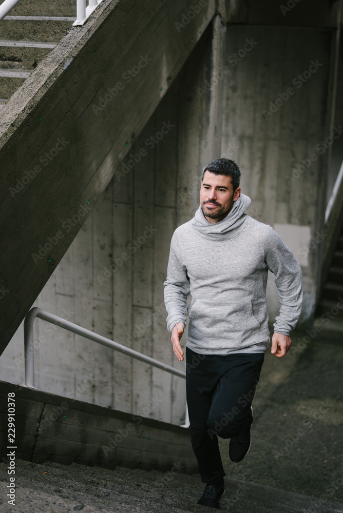 Obraz premium Urban athlete running on stairs. Sporty man training outside