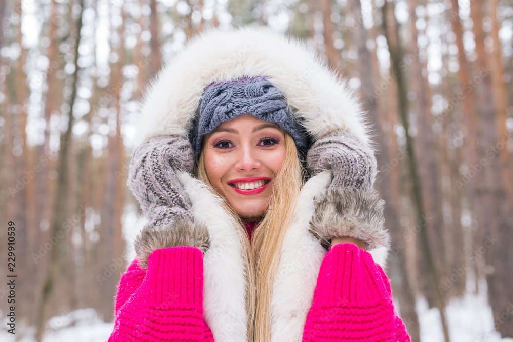 Fashion, winter and people concept - Young attractive woman dressed in fur waistcoat over snowy nature background Fashion, winter and people concept - Young attractive woman dressed in fur waistcoat over snowy nature background