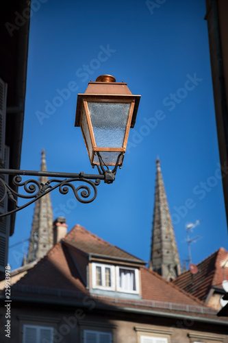 Street lantern, roofs, spiers and sky. Details of the town Obernai, France photo