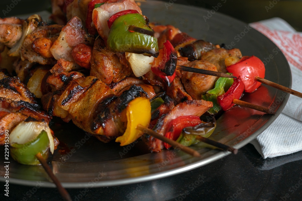 Barbecue skewers with meat and vegetables jn the wood sticks. Meat grilled shish kebab. Fried meat on the plate