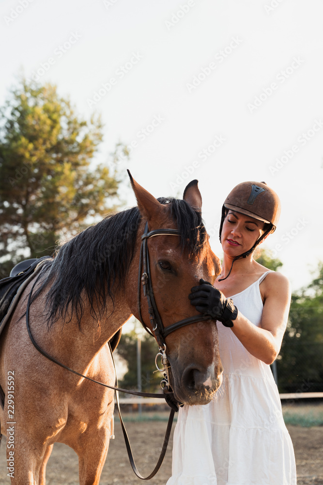 Portrait of woman stroking horse StockFoto Adobe Stock