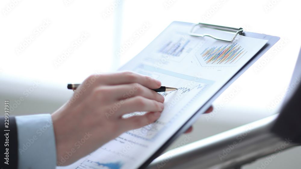 Close up businessman working with graph data at office Close up businessman working with graph data at office