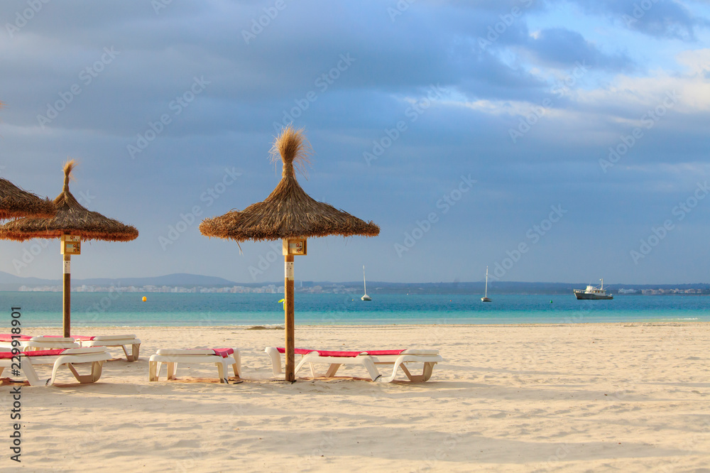 Fototapeta premium Empty deck chairs and umbrellas on the beach in Port de Alcudia