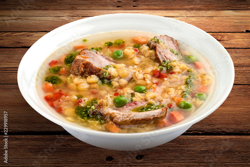 Pea soup with pork ribs. On a wooden background