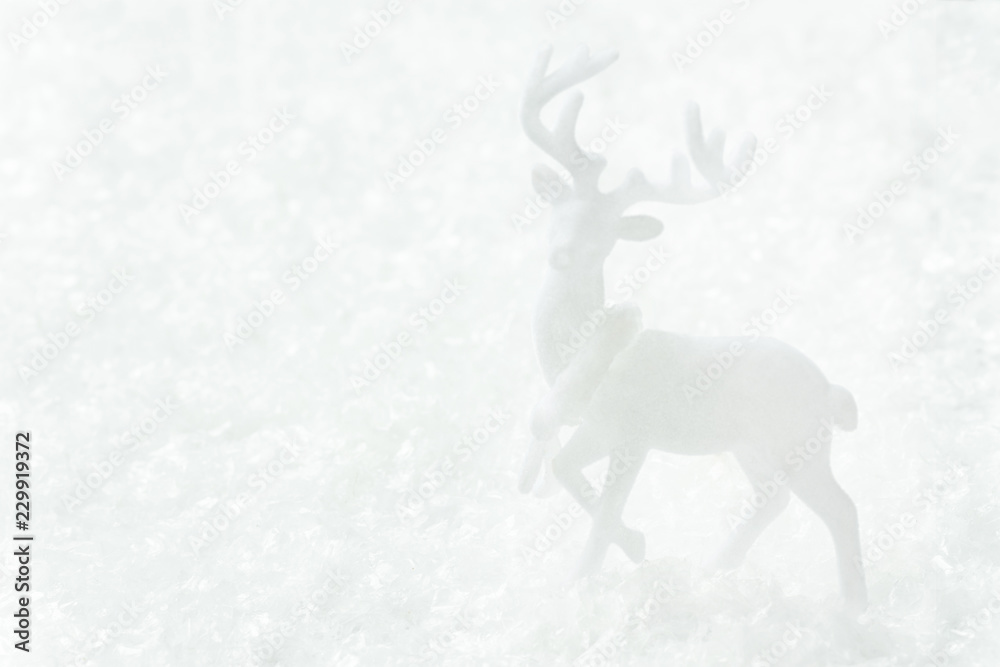 White deer standing in snow forest. Magic winter scene. Christmas New Year greeting card poster banner in monochrome. Minimalist creative image in scandinavian style. Copy space for text.