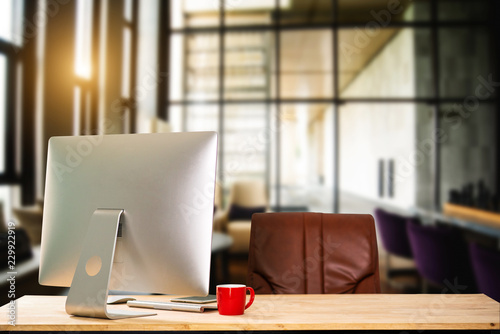 workspace with computer, laptop, office supplies, and coffee cup, smartphone, and tablet at office. desk work concept. in morning light