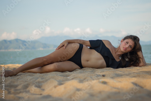 Beautiful brunette woman lying and relaxing on the beach