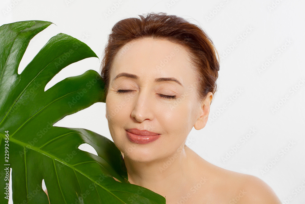 Beauty middle age woman macro face portrait. Spa and anti aging concept and leaf Isolated on white background. Plastic surgery and collagen face injections.Wrinkles and menopause. Mock up. Copy space. Beauty middle age woman macro face portrait. Spa and anti aging concept and leaf Isolated on white background. Plastic surgery and collagen face injections.Wrinkles and menopause. Mock up. Copy space.