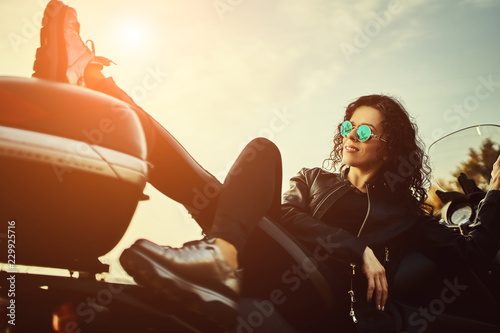 Vászonkép Young woman resting sitting on a motorcycle