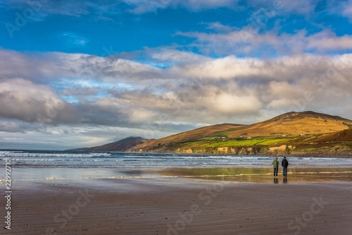 Couple walking at the Atlantic Ocean Shore. Inch Beach in Ireland. 