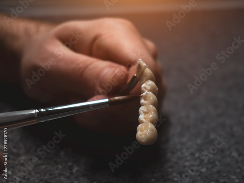A dental technician makes a prosthetic teeth. laboratory. close-up.