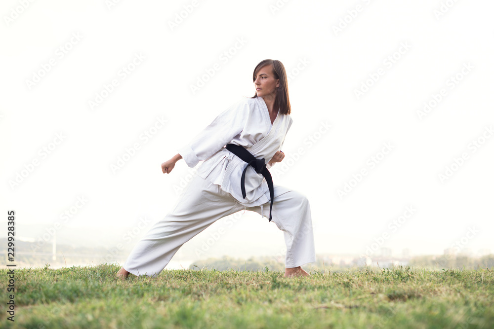 A young karate professional practicing while wearing a black belt. A young karate professional practicing while wearing a black belt.