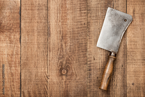 Vintage butcher cleaver on wooden background