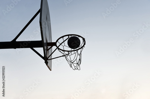 Silhouette of a basketball hoop and backboard at sunset © scottdavis2