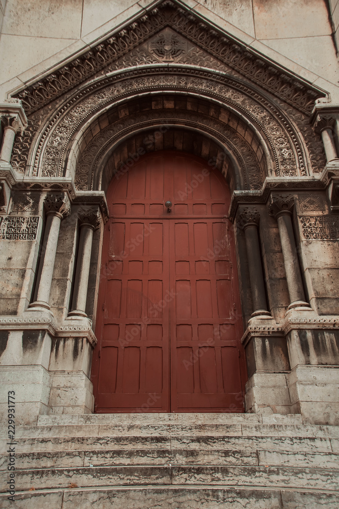 The amazing facade of the Basilica, large maroon vintage doors. Basilica Sacré Coeur, Paris, France.