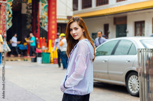 A woman standing in front of a shrine at Chinatown, Yaowarat, Bangkok, Thailand.