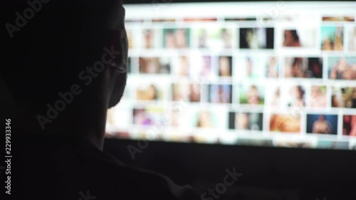 Young mand watching naked women in the computer screen photo