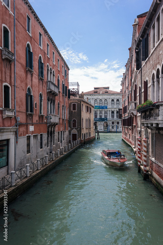 Rotes Boot fährt durch Venedig Kanal 