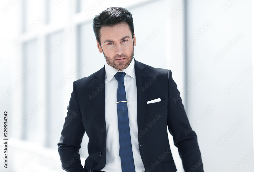serious businessman standing near an office window serious businessman standing near an office window