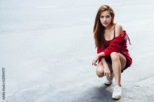 Travelers Asian woman wearing a white long-sleeved casual wear red. Sitting on the street at Yaowarat Road in Bangkok, Thailand with copy space.