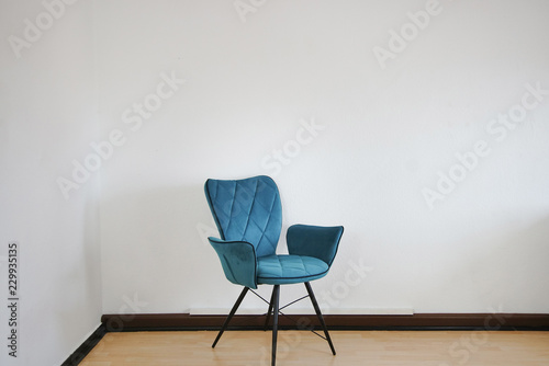 blauer Stuhl vor weißer Wand