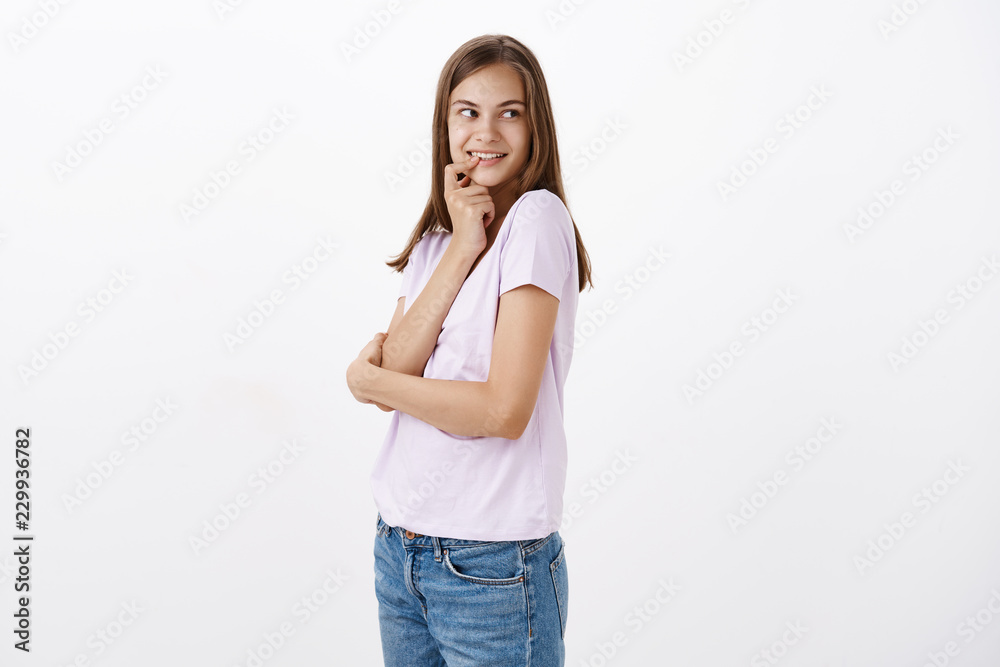 That guy seems cute. Portrait of intrigued and flirty feminine attractive woman with brown long hair biting finger and smiling with curious look turning right having intention or thought in mind That guy seems cute. Portrait of intrigued and flirty feminine attractive woman with brown long hair biting finger and smiling with curious look turning right having intention or thought in mind