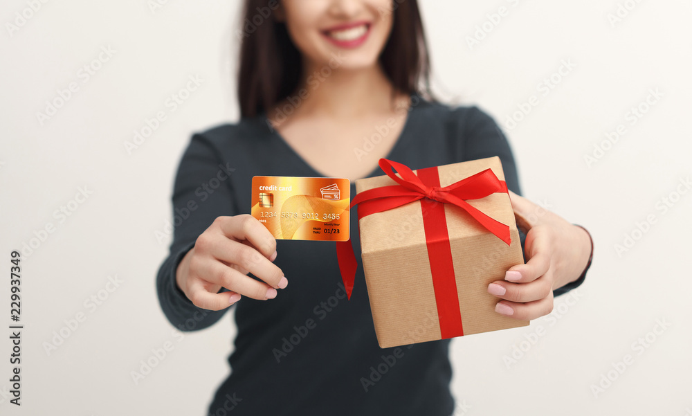 Beautiful woman holding credit card and gift box Beautiful woman holding credit card and gift box