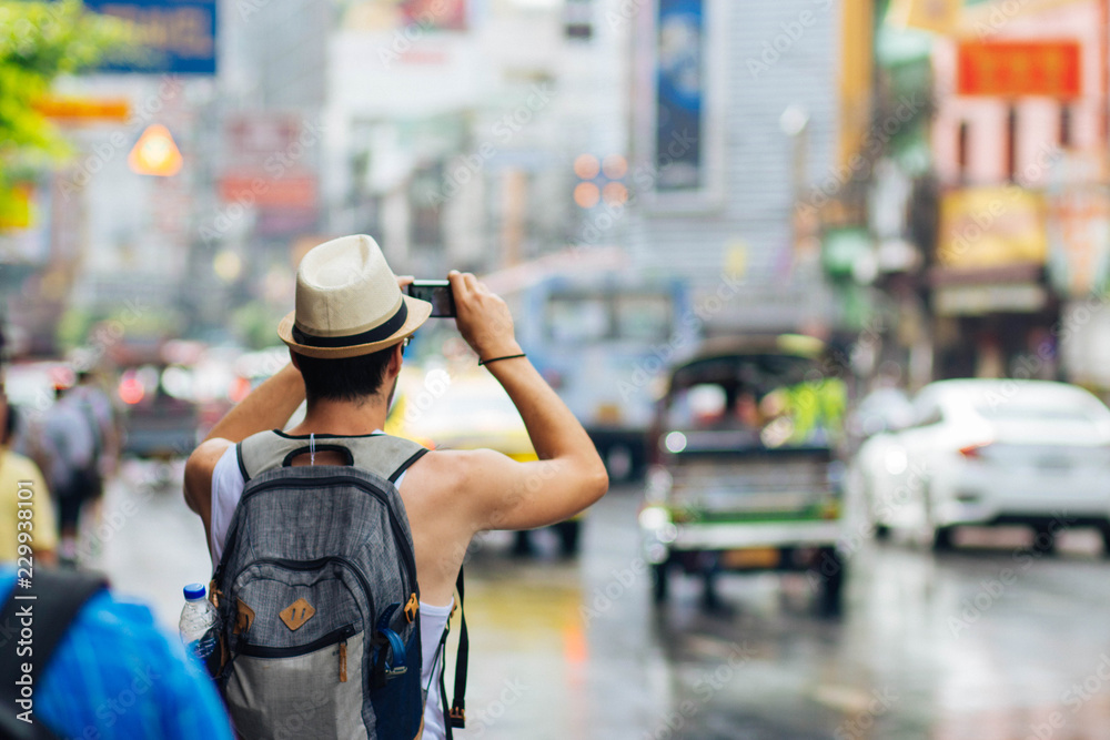 The tourists are taking a photo of the view of Bangkok's Chinatown. The tourists are taking a photo of the view of Bangkok's Chinatown.